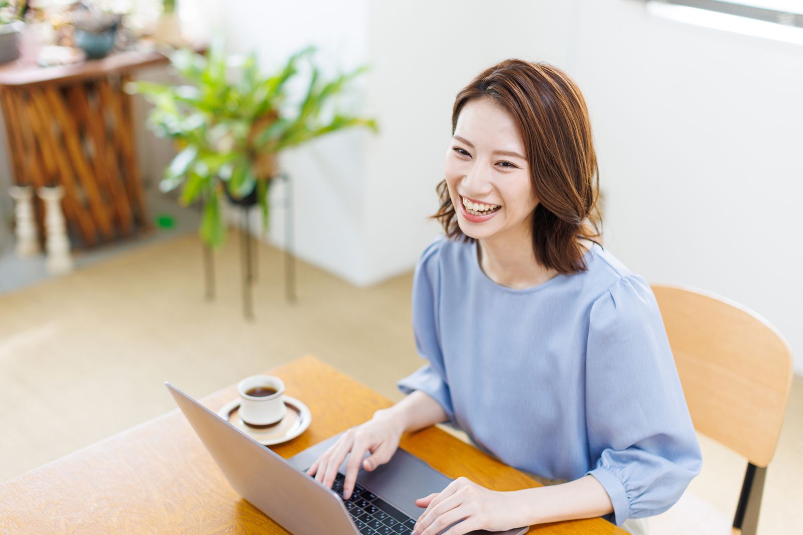 自宅でパソコンに向かい笑顔で働く女性
